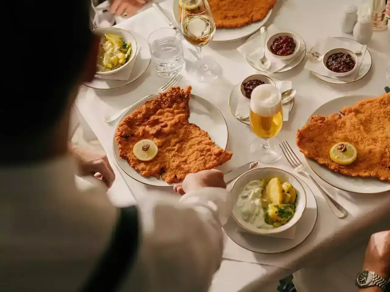 Tisch mit Schnitzel, Salat, Wein und Bier - typisch wienerisch