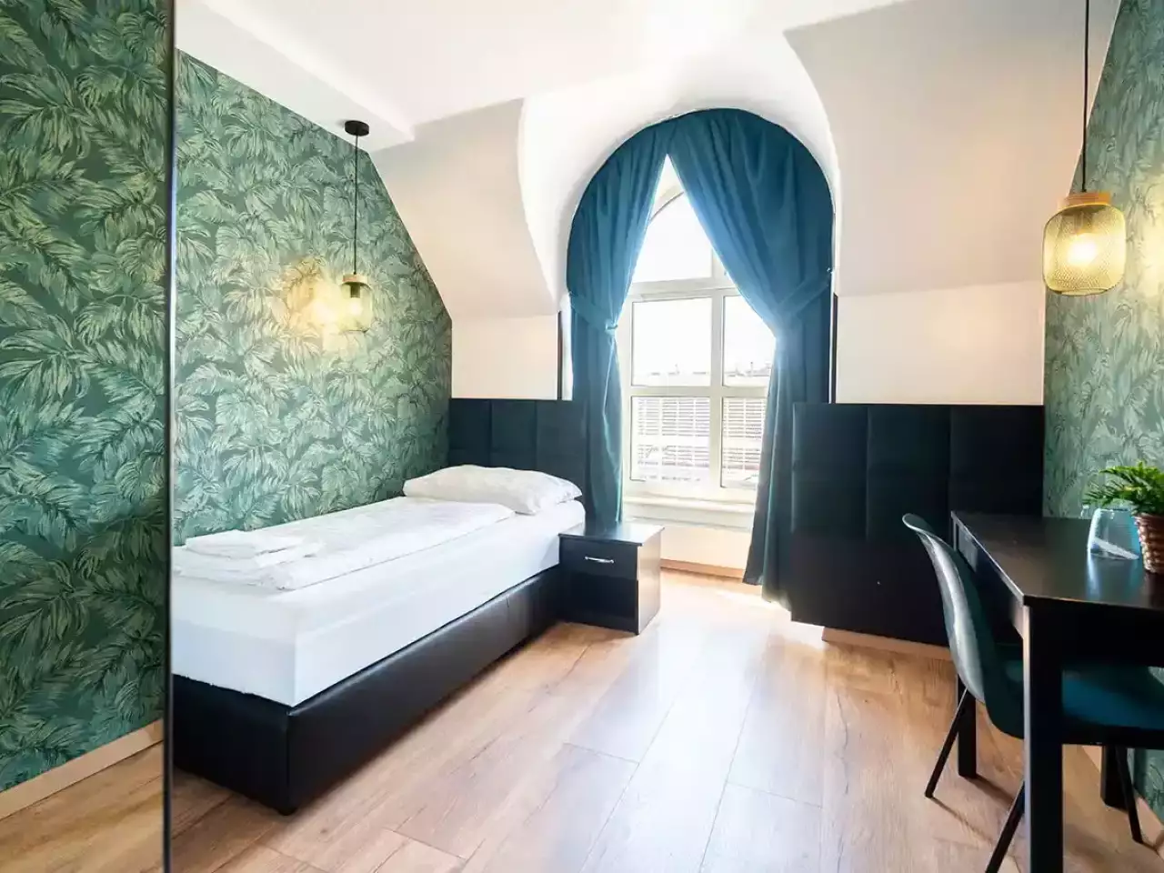 Einzelzimmer mit Fenster und Schreibtisch