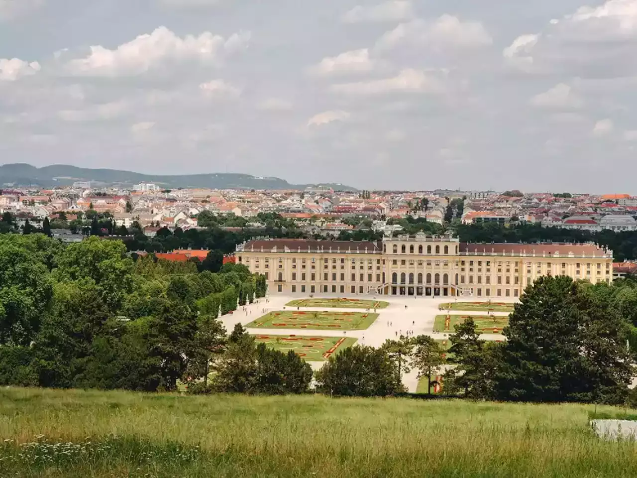 Blick auf das Schloss Schönbrunn in Wien mit der Stadt im Hintergrund